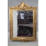 A gilt framed pier mirror with bevelled plate in foliate decorated frame. H.150 W.103 cm.