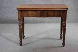 A 19th century mahogany tea table with fold over top and gateleg action on turned tapering supports.