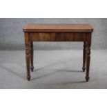 A 19th century mahogany tea table with fold over top and gateleg action on turned tapering supports.
