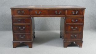 A Georgian style mahogany pedestal desk with inset tooled leather top on bracket feet. H.78 W.136