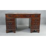 A Georgian style mahogany pedestal desk with inset tooled leather top on bracket feet. H.78 W.136