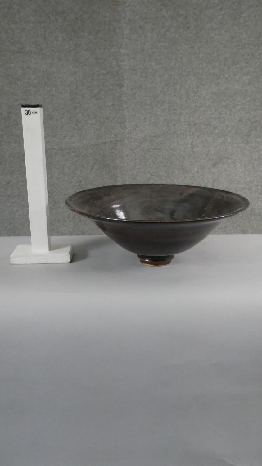 A large footed art pottery bowl with brown and black glaze with flared rim. (Damaged as seen in - Image 6 of 6