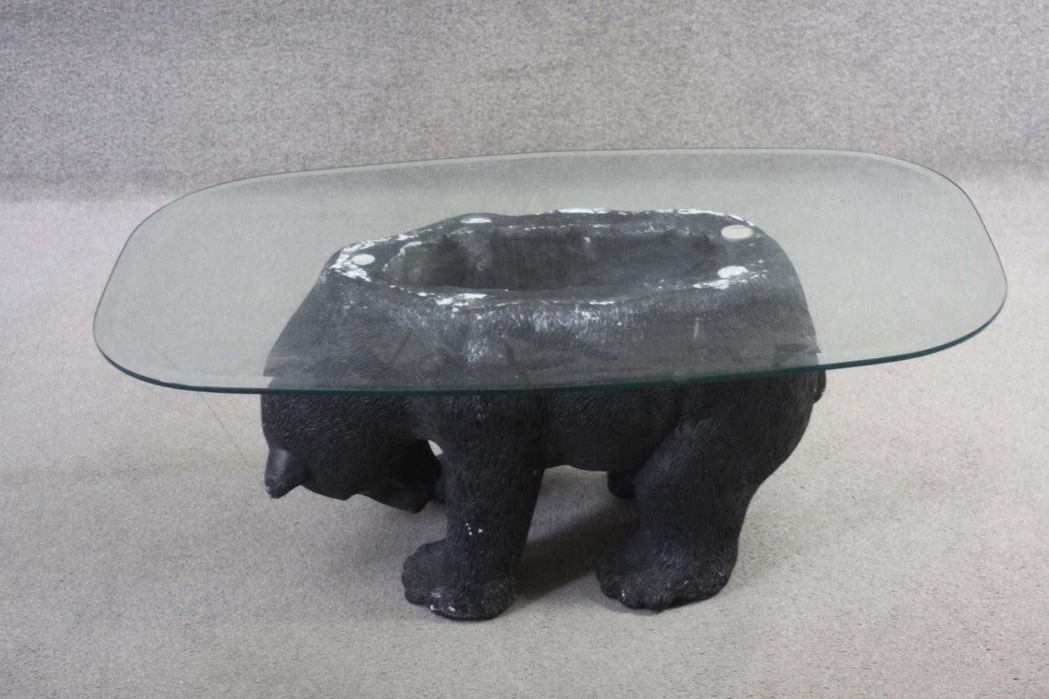 A plate glass topped coffee table with pedestal modelled as a plaster standing bear. H.40 W.70 D.