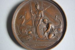 A 19th century bronze medal. One side with a relief portrait of Queen Victoria, the reverse with
