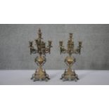 A pair of Continental style brass four branch candelabras with floral and foliate design each on