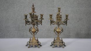 A pair of Continental style brass four branch candelabras with floral and foliate design each on