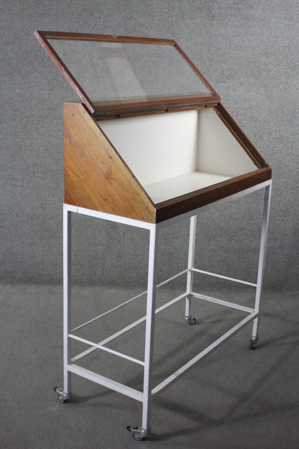 A lidded glazed mahogany display case on metal framed stand fitted with locking castors, from the - Image 4 of 5