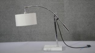 A contemporary adjustable chrome branched table light with white circular shade. H.49 W.58 D.14 cm