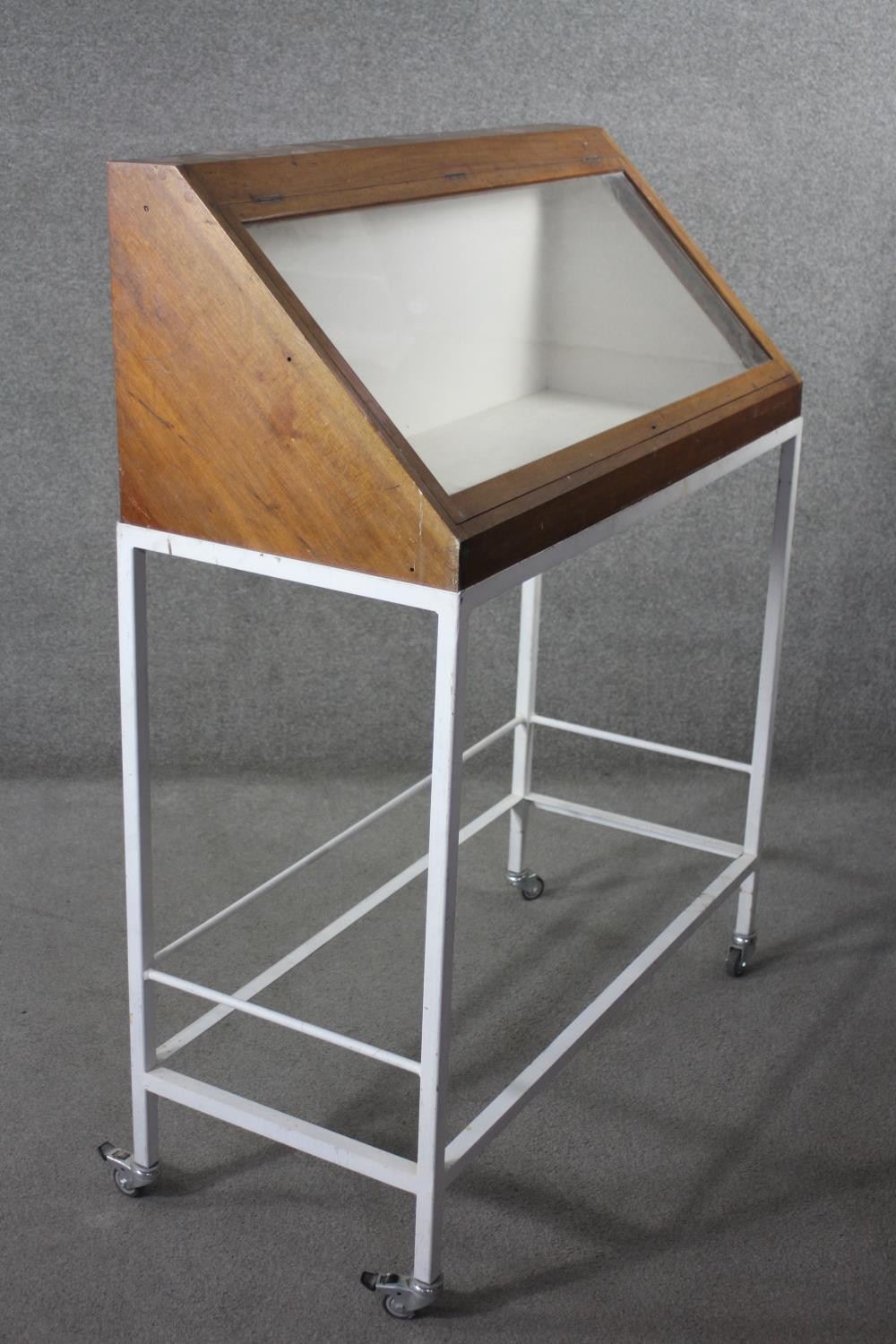 A lidded glazed mahogany display case on metal framed stand fitted with locking castors, from the - Image 3 of 5