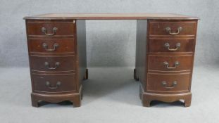 A Georgian style mahogany three part pedestal desk with shaped inset gilt tooled leather top above