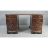 A Georgian style mahogany three part pedestal desk with shaped inset gilt tooled leather top above