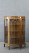 A mid century Art Deco style walnut display cabinet of bowed outline on cabriole supports. H.125 W.