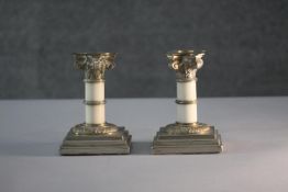 A pair of Victorian squat Corinthian column candle sticks with gilt brass tops above ivory columns