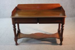 A mid 19th century mahogany side table with galleried back above frieze drawers on turned supports