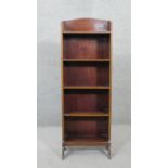 An Edwardian mahogany and satinwood strung narrow open bookcase on shaped supports. H.117 W.41 D.17