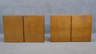 A pair of vintage teak wall cabinets fitted with panel doors enclosing shelves. H.56 W.84 D.27 cm