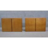 A pair of vintage teak wall cabinets fitted with panel doors enclosing shelves. H.56 W.84 D.27 cm