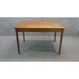 A vintage teak dining table fitted with integral fold out central leaf on circular section