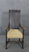 A 19th century oak Carolean style armchair with scroll cresting to the back rail and raised on