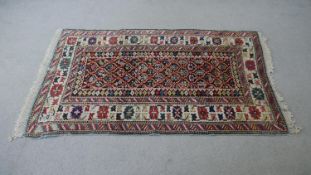 A blue ground fine handmade Caucasian rug. All over floral motif within a stylised border. L.157 W.