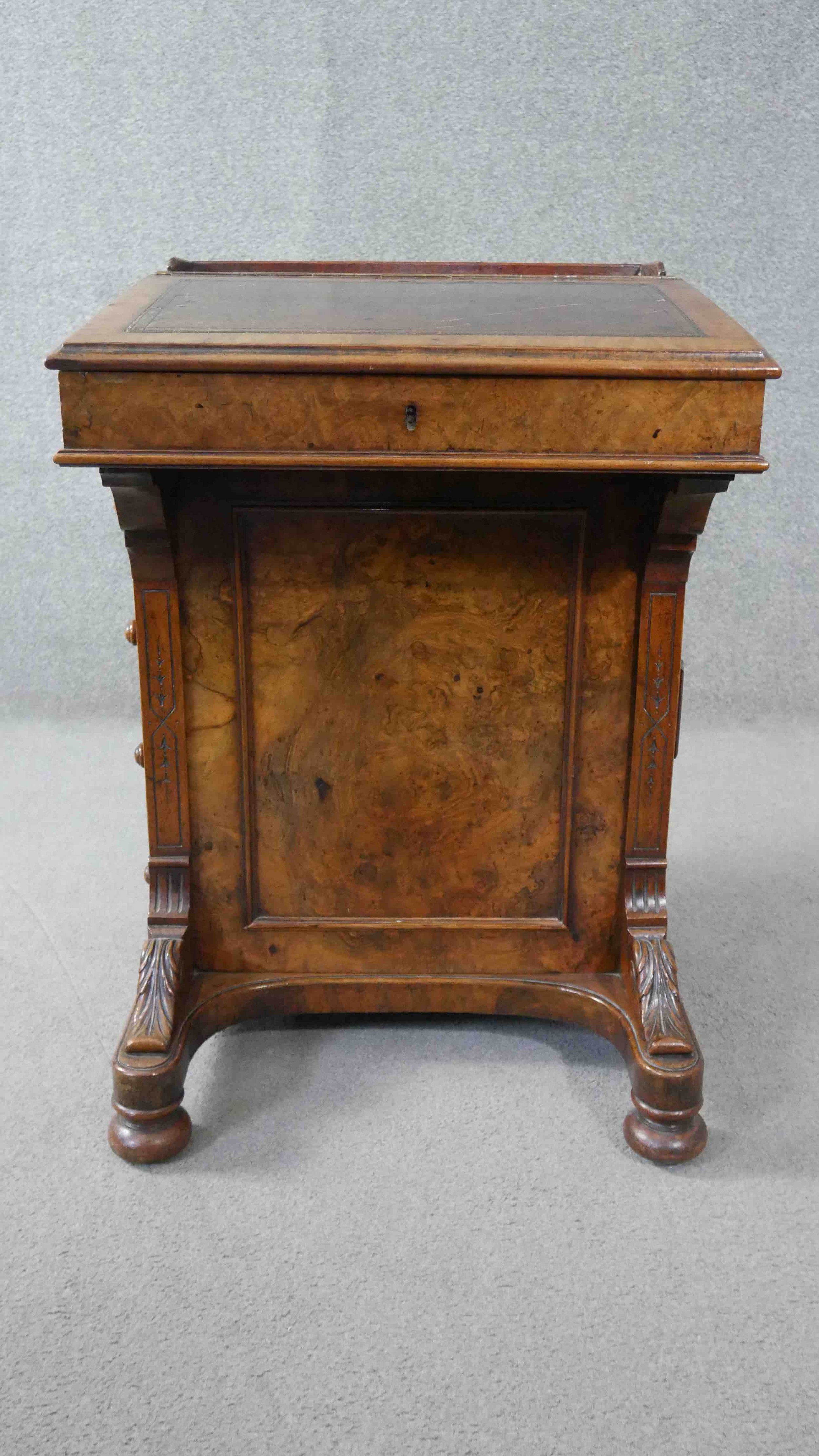 A Victorian walnut Davenport with hinged sloped leather lined writing surface above four drawers