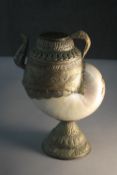 An Asian pearl nautilus shell and brass water jug with engraved detailing. (shell damaged) H.26 W.17