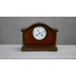 An Edwardian mahogany and satinwood inlaid mantel clock with white enamel dial flanked by brass