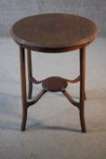 An Edwardian mahogany and satinwood strung occasional table on swept supports united by under