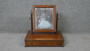 A 19th century mahogany toilet mirror with adjustable swing mirror on platform base fitted with