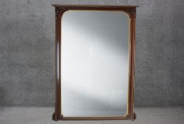 A large late 19th century walnut and gilt overmantel mirror in carved architectural style frame,