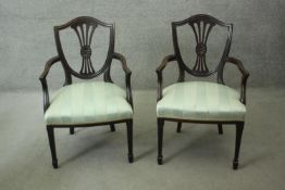A pair of mahogany Hepplewhite style open armchairs with shaped pierced splats above stuffover seats