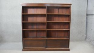 A late 19th century mahogany open bookcase fitted with adjustable shelves and base cupboard on