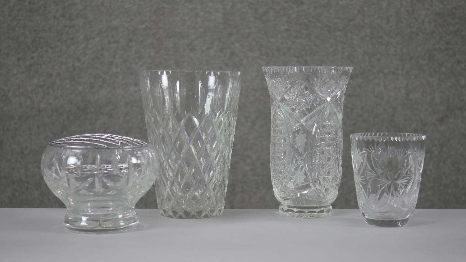 A collection of four cut crystal flower vases with stylised foliate design. H.20 Diam.15cm (largest)