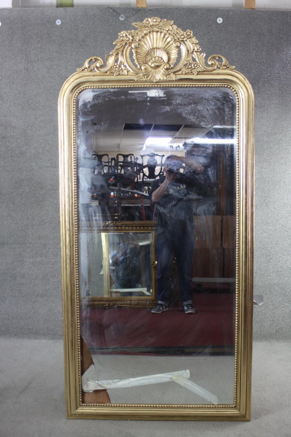 A full height gilt framed pier mirror with arched plate in moulded and beaded frame with shell