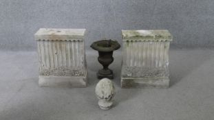 Two cast concrete fluted design pedestal bases, along with a pineapple finial and a cast iron
