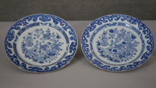 A pair of large Kangxi blue and white hand painted porcelain chargers. Decorated with stylised