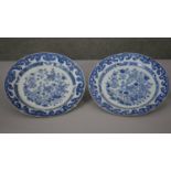 A pair of large Kangxi blue and white hand painted porcelain chargers. Decorated with stylised