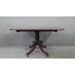 A Regency mahogany tilt top dining table on quadruped carved and swept supports terminating in brass