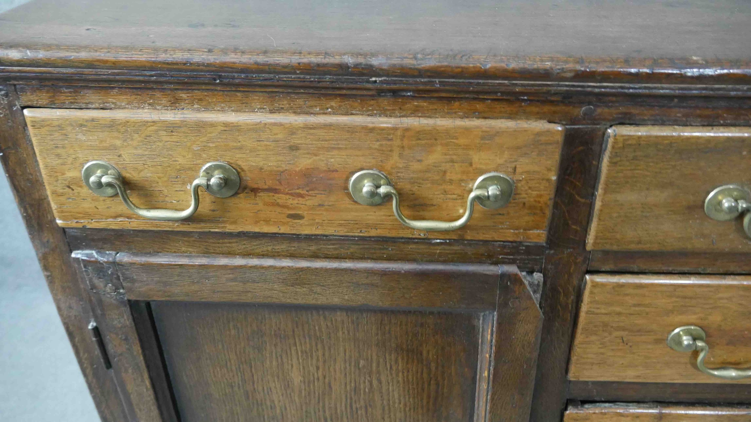 A Georgian country oak dresser base fitted with central drawers with brass swan neck handles flanked - Image 5 of 7