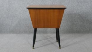A 1960's vintage teak sewing table with lift out fitted interior and contents, with makers label,