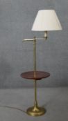 A vintage brass standard reading lamp with mahogany tray top central tier, height adjustable with