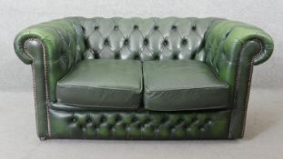 A two seater Chesterfield sofa in deep buttoned studded leather upholstery. H.66 W.134 D.76CM