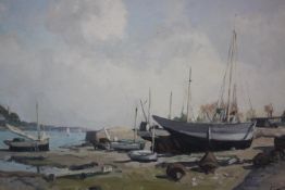 A framed oil on canvas of fishing boats on the shore. Indistinctly signed. H.44 W.51cm.