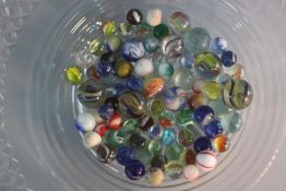 A collection of seventy five early 20th and 19th century cane twist marbles. Including a rainbow