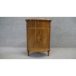 A Continental mahogany crossbanded bow fronted corner cabinet with central Classical urn inlaid