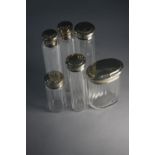 A collection of 19th century silver topped and faceted glass dressing table bottles and jars. H.