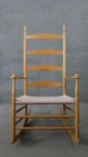 A pale beech Shaker style rocking chair with woven seat.