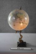 A Victorian style globe on brass dolphin design stand. H.53 Diameter.29cm.