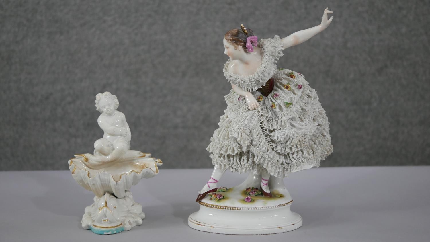 Two porcelain figures. A 19th century Dresden hand painted ballet dancer with porcelain lace