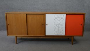 A 1960's vintage teak sideboard with laminated composite sliding doors on tapering circular